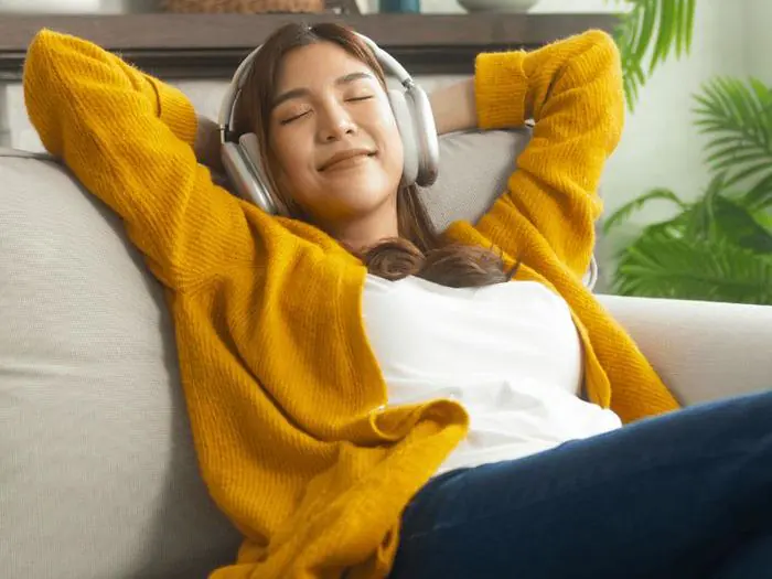 Person relaxing comfortably at home with headphones on, representing the cellular wellness support of Natural Nrf2 Activation at Dr. Crystal's Chiropractic Care