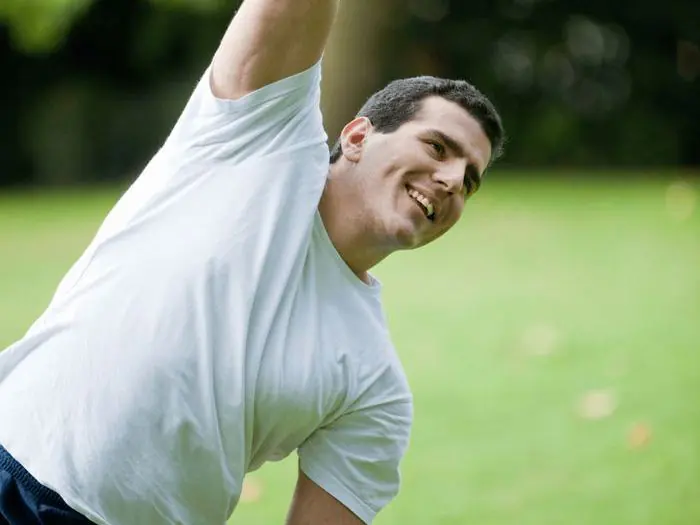 Person stretching and smiling outdoors after recovery, representing PEMF therapy benefits at Dr. Crystal's Chiropractic Care in Le Claire, Iowa